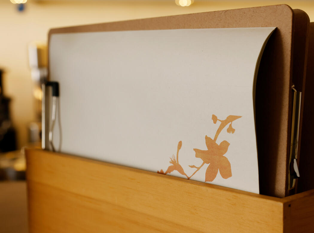 Menus do Veggieterraneo em papel, com o motivo floral da identidade do restaurante